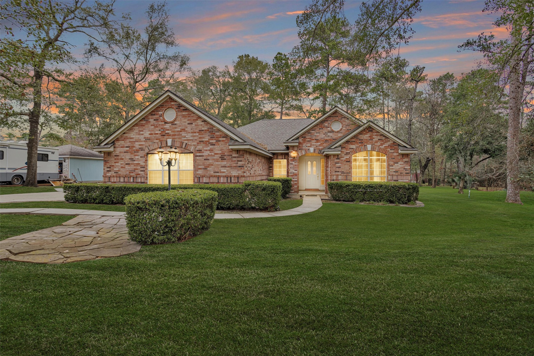 a front view of a house with a yard and trees