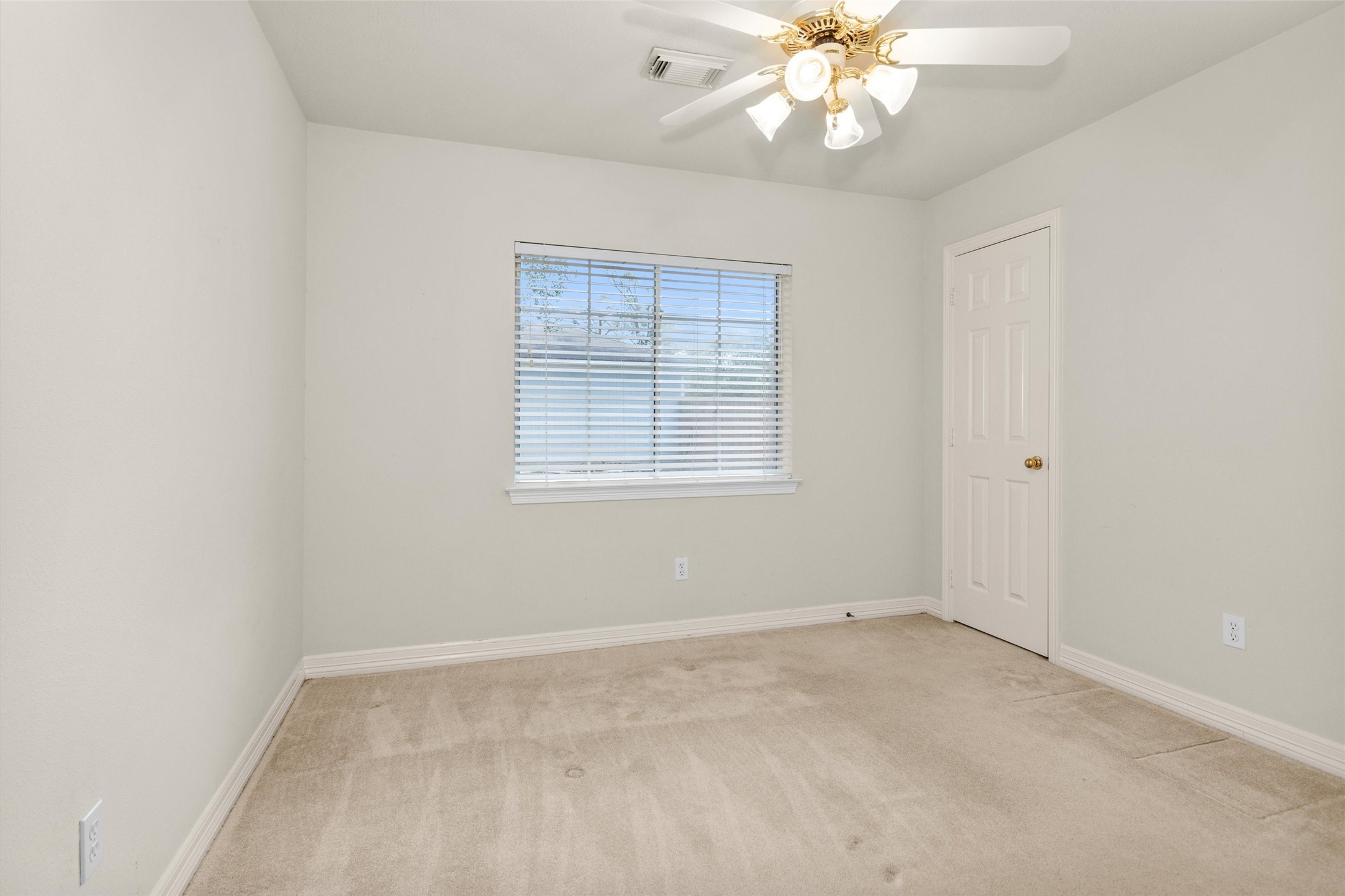 2419 Carriage Ridge Lane Conroe, TX 77384 - Photo 29 of 39 an empty room with a chandelier fan and windows