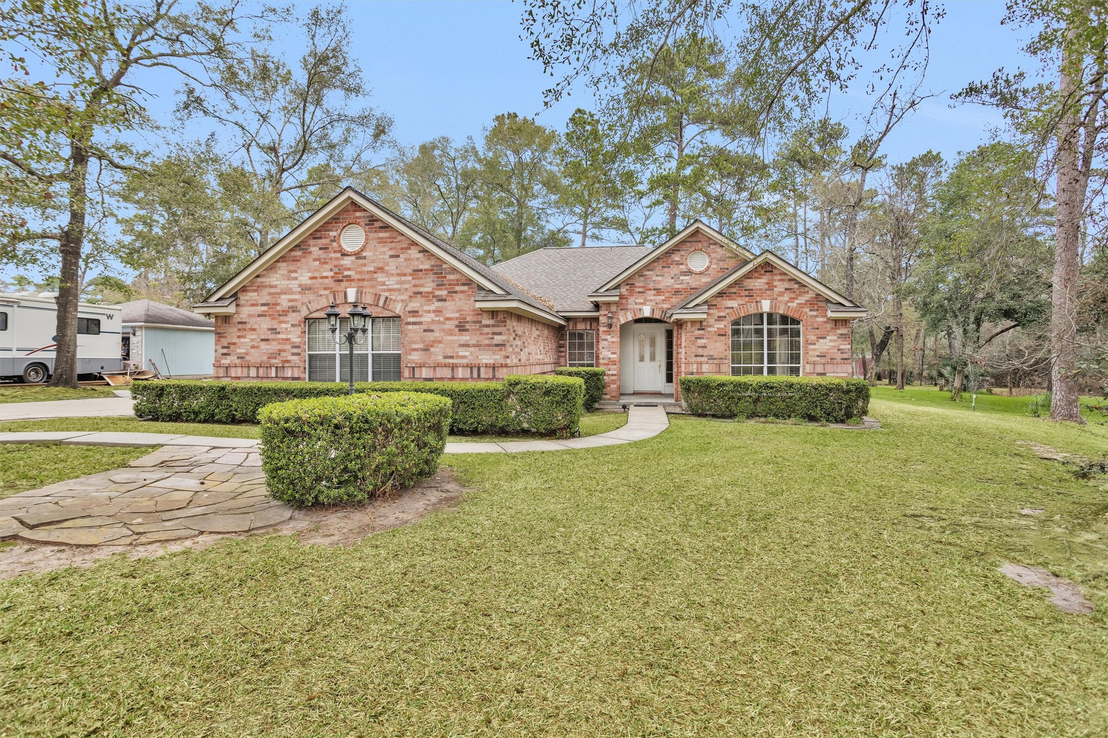 2419 Carriage Ridge Lane Conroe, TX 77384 - Photo 4 of 39 a front view of a house with a yard and potted plants