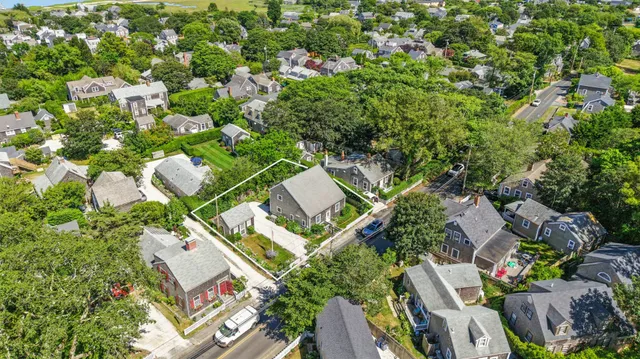 an aerial view of residential house with outdoor space and trees all around