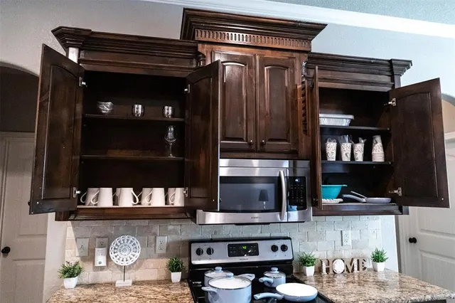 a kitchen with a refrigerator and a stove top oven