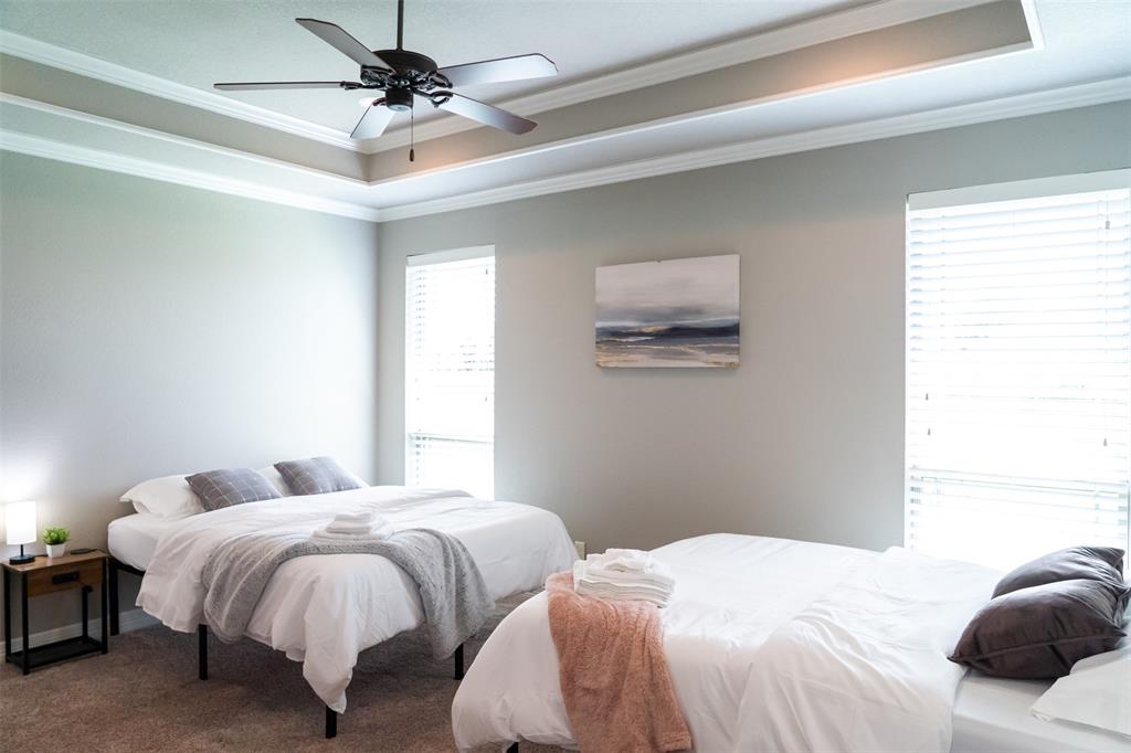 7352 Kingsport Lane Tyler, TX 75703 - Photo 17 of 38 a bedroom with two beds and a ceiling fan