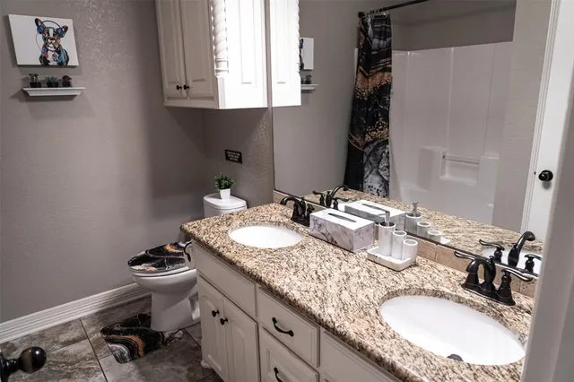 a bathroom with a granite countertop sink a mirror and vanity