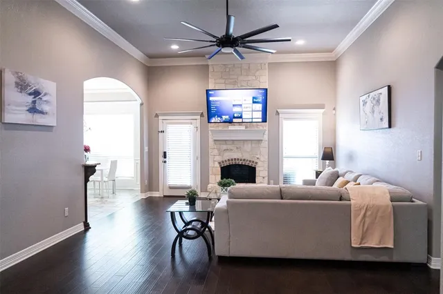 a living room with furniture a fireplace and a ceiling fan