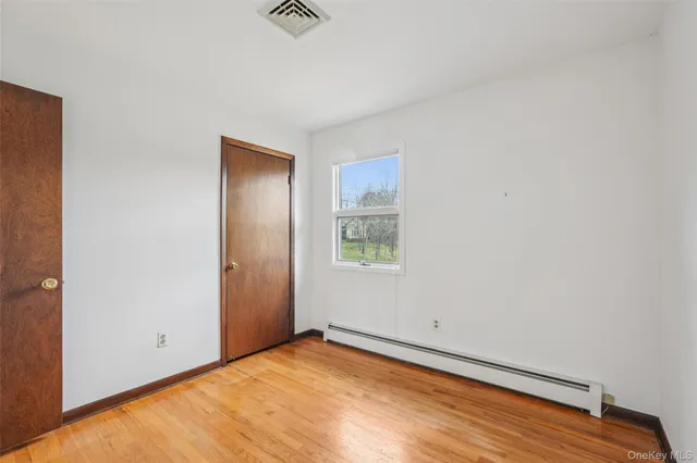 a view of an empty room with wooden floor