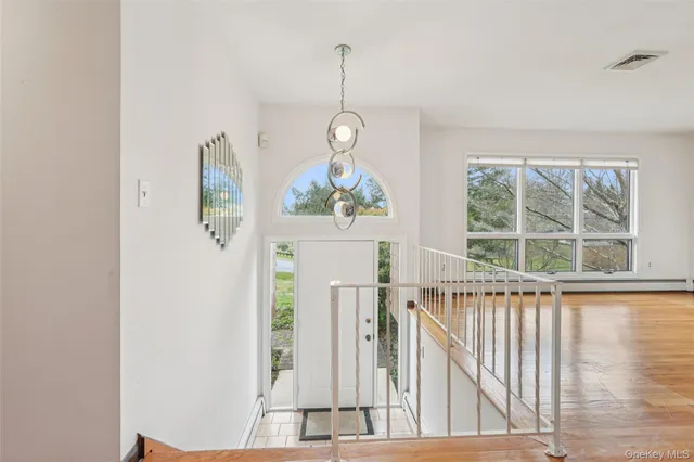a view of a room with wooden floor windows and a chandelier