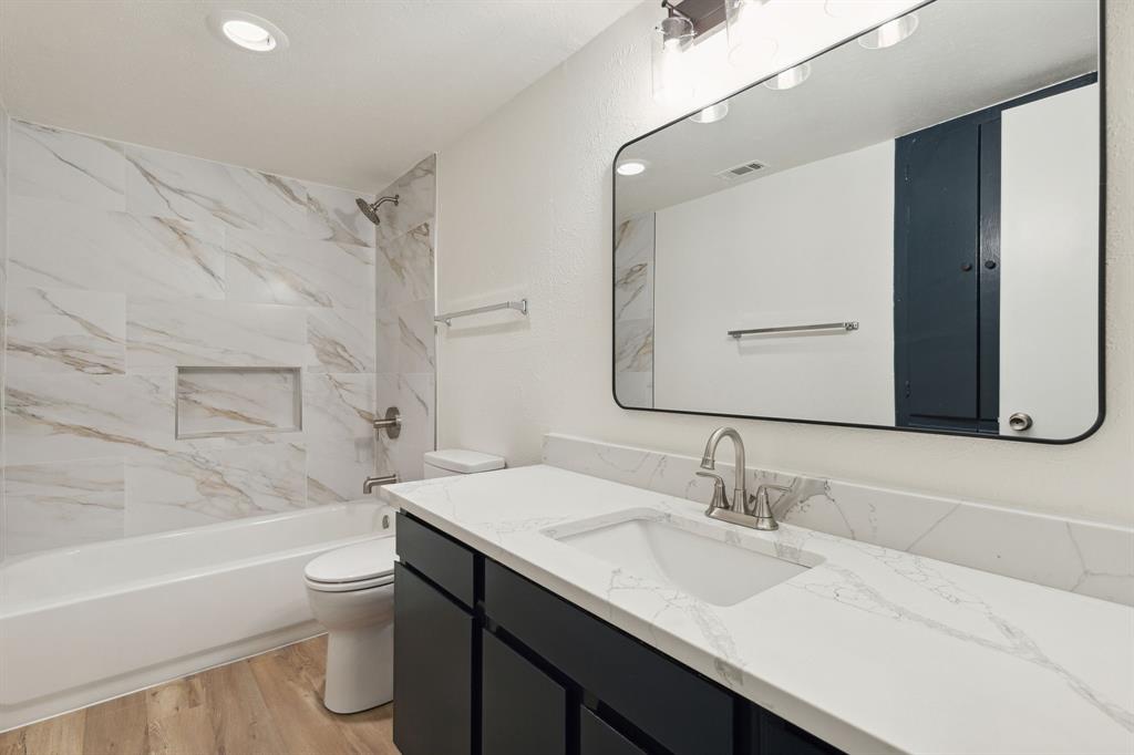 3827 Gilbert Avenue, Unit 214 Dallas, TX 75219 - Photo 18 of 25 a bathroom with a sink toilet vanity and shower