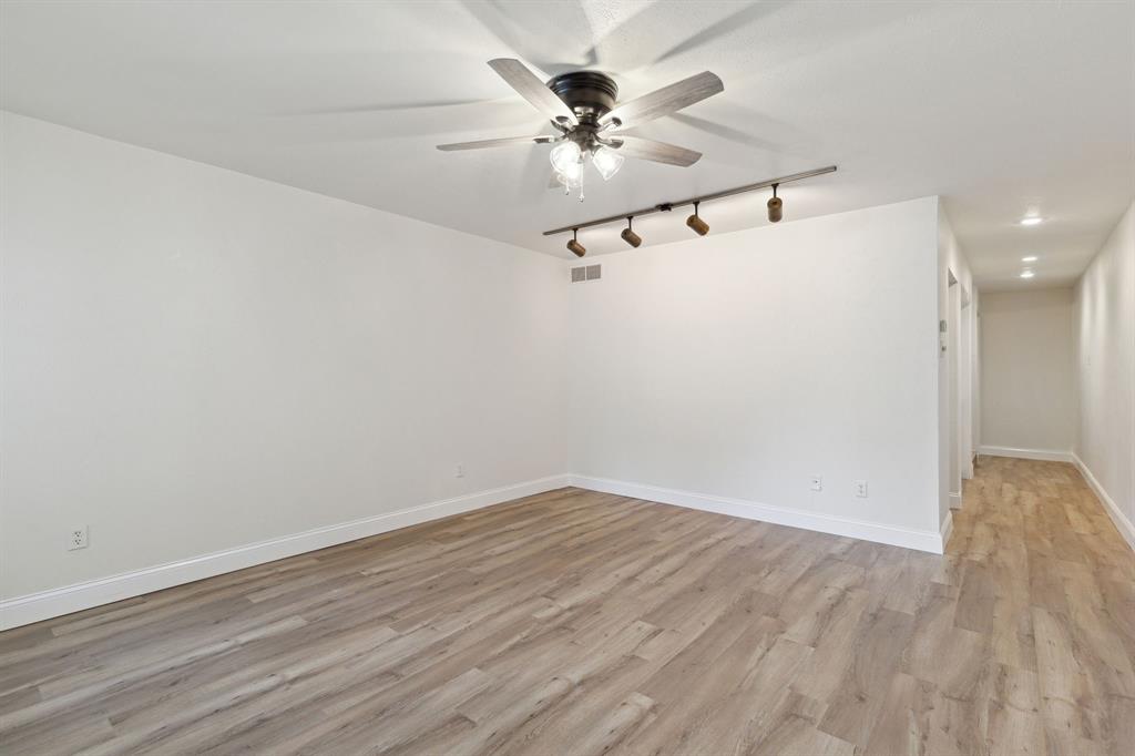 3827 Gilbert Avenue, Unit 214 Dallas, TX 75219 - Photo 3 of 25 a view of a room with wooden floor and a ceiling fan