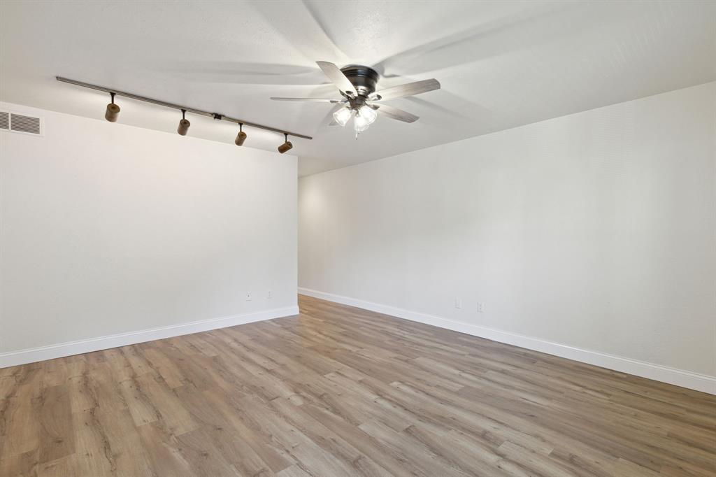 3827 Gilbert Avenue, Unit 214 Dallas, TX 75219 - Photo 4 of 25 a view of a room with wooden floor and a ceiling fan
