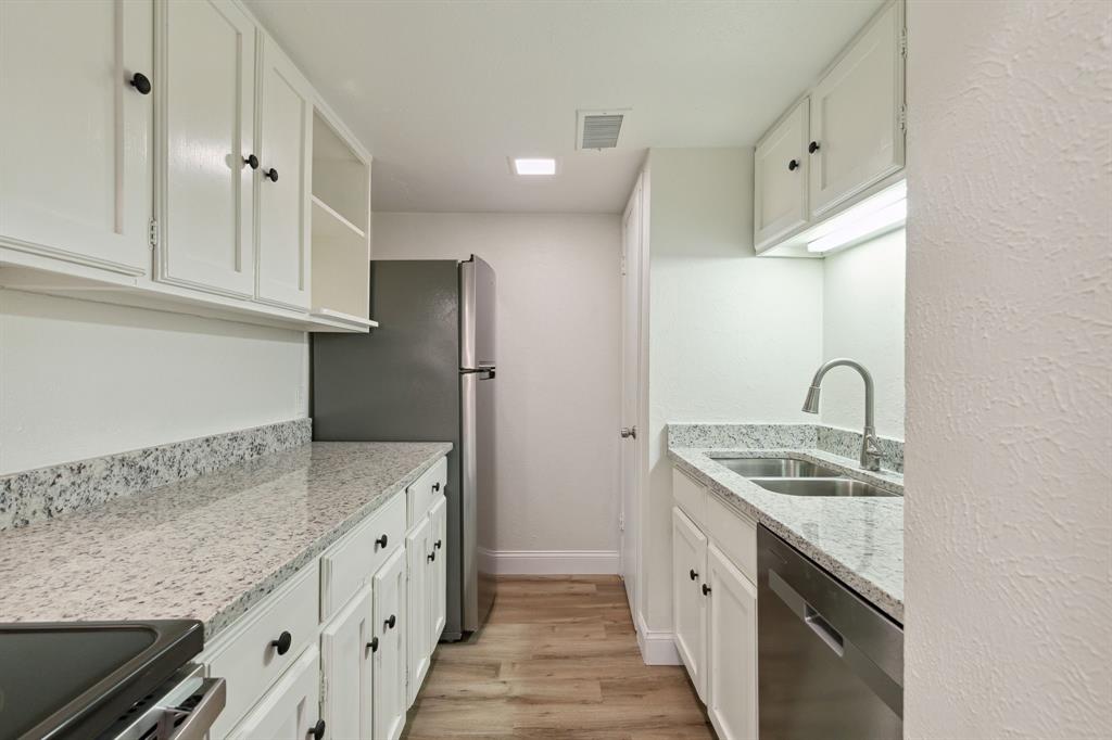 3827 Gilbert Avenue, Unit 214 Dallas, TX 75219 - Photo 7 of 25 a kitchen with stainless steel appliances granite countertop a sink stove and refrigerator