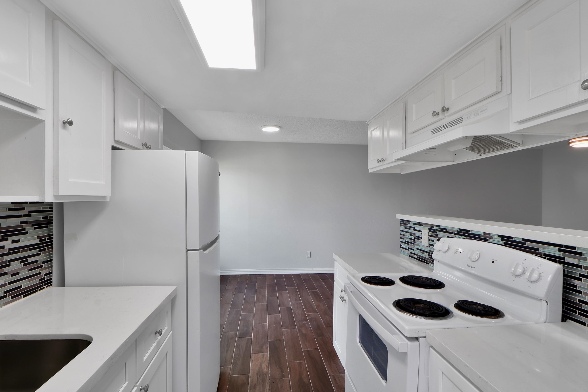 7047 Bissonnet Street, Unit 117 Houston, TX 77074 - Photo 8 of 17 a kitchen with stainless steel appliances kitchen island a sink a stove and refrigerator