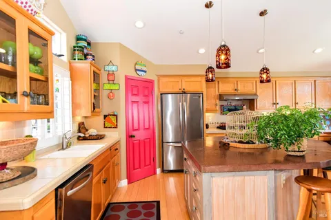 a kitchen with stainless steel appliances kitchen island granite countertop a table and chairs in it