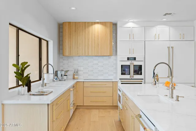 a kitchen with kitchen island granite countertop a sink a counter cabinets and appliances