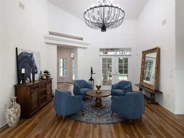 a living room with furniture chandelier and wooden floor