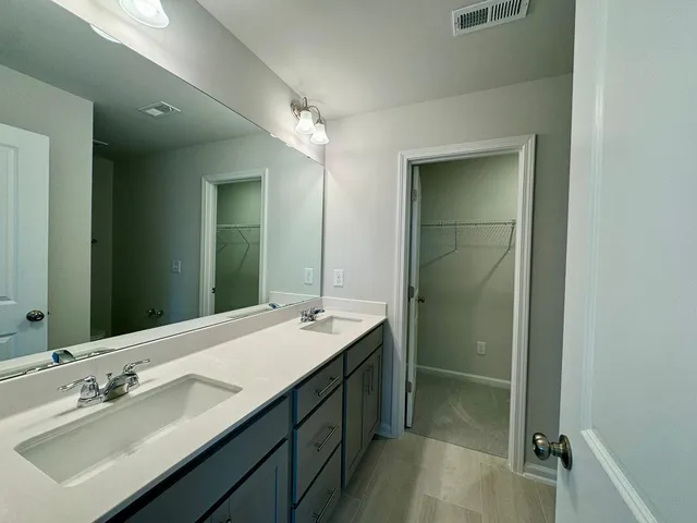 a bathroom with a double vanity sink mirror and shower