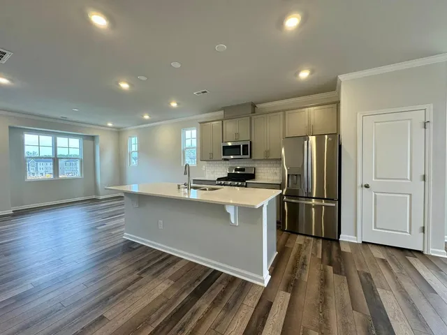 a kitchen with stainless steel appliances a refrigerator and wooden floor