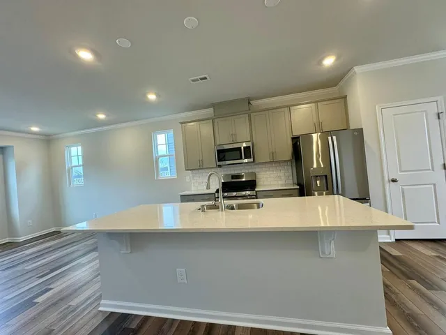 a kitchen with stainless steel appliances a refrigerator sink and stove