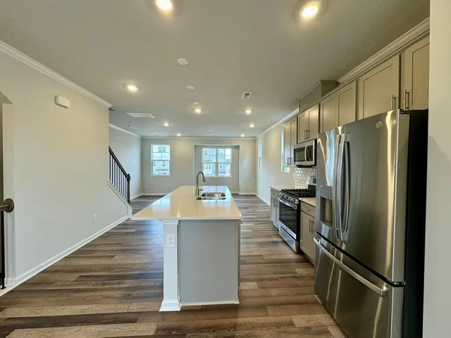 a large kitchen with stainless steel appliances a refrigerator and a stove top oven