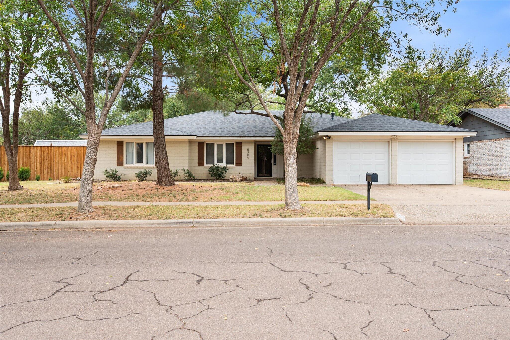 5309 77th Street Lubbock, TX 79424 - Photo 1 of 37 a front view of a house with a yard and garage