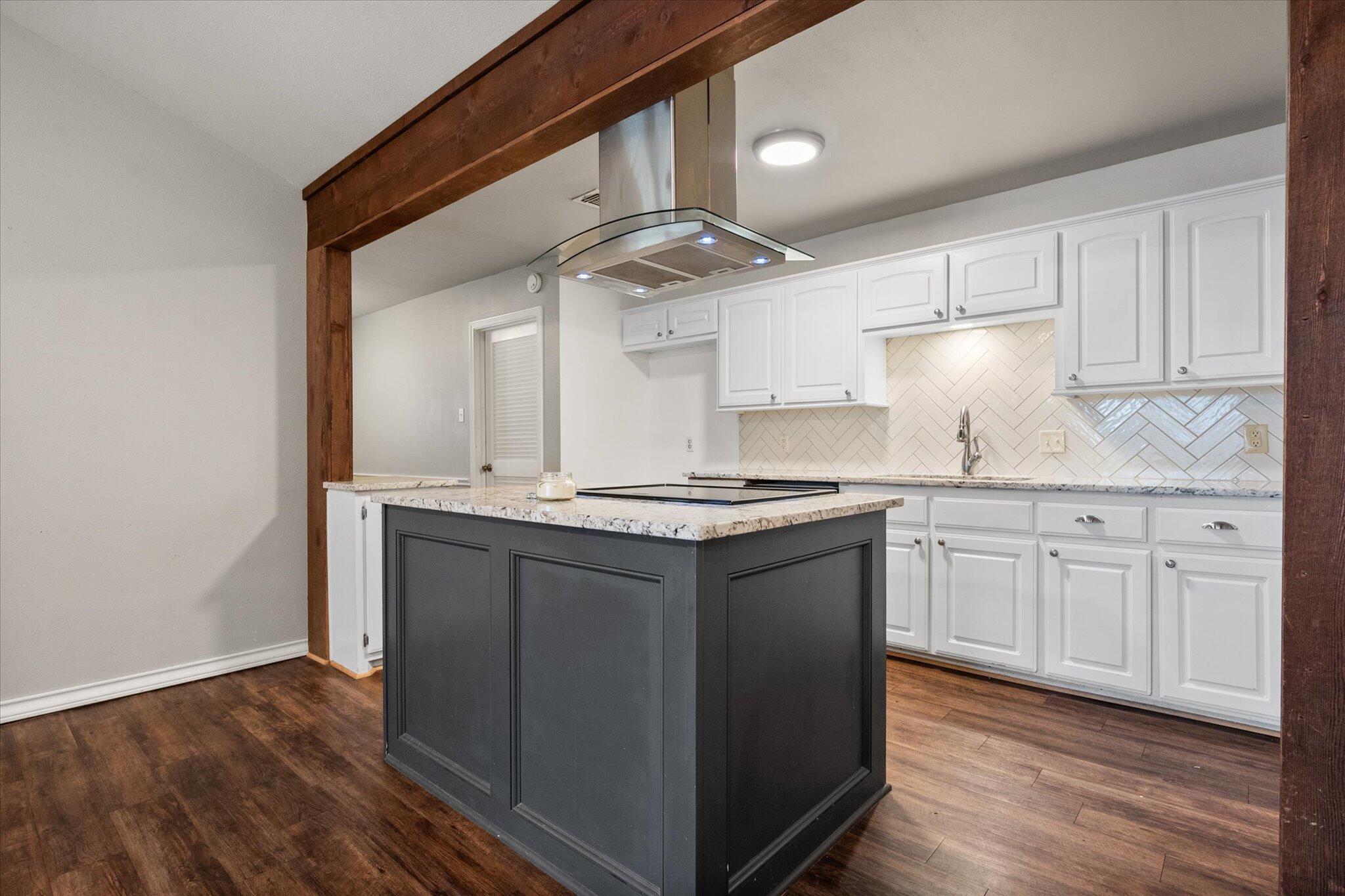 5309 77th Street Lubbock, TX 79424 - Photo 15 of 37 a kitchen with granite countertop a sink cabinets and stainless steel appliances