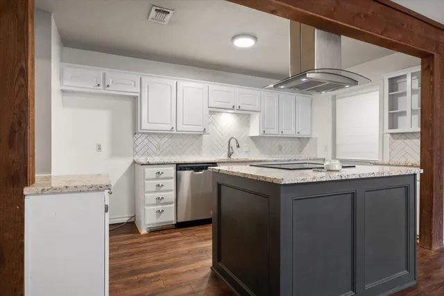 a kitchen with granite countertop a sink cabinets and stainless steel appliances