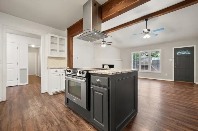 a kitchen with stove and wooden floor