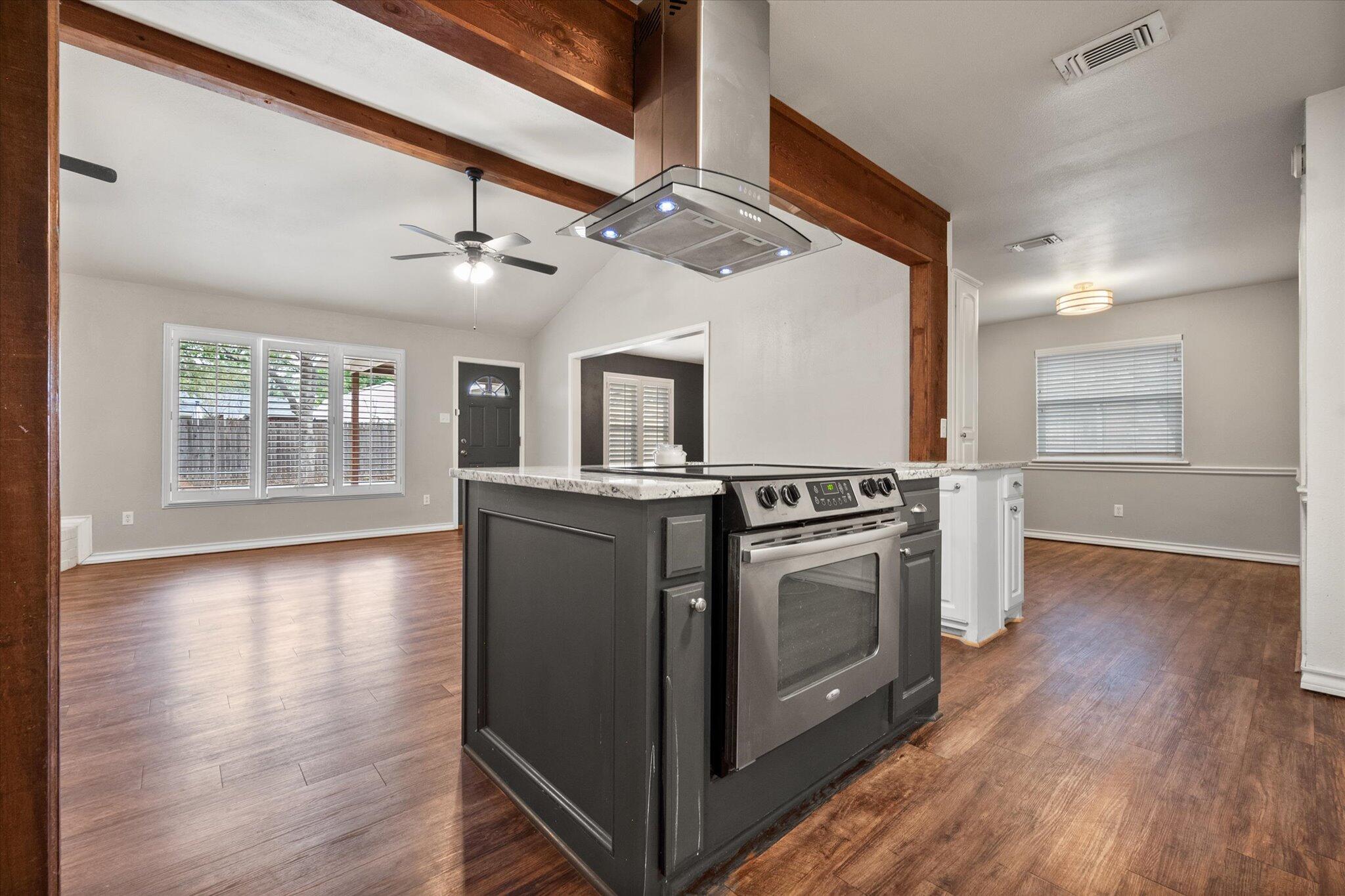 5309 77th Street Lubbock, TX 79424 - Photo 18 of 37 a view of a kitchen with wooden floors and stainless steel appliances