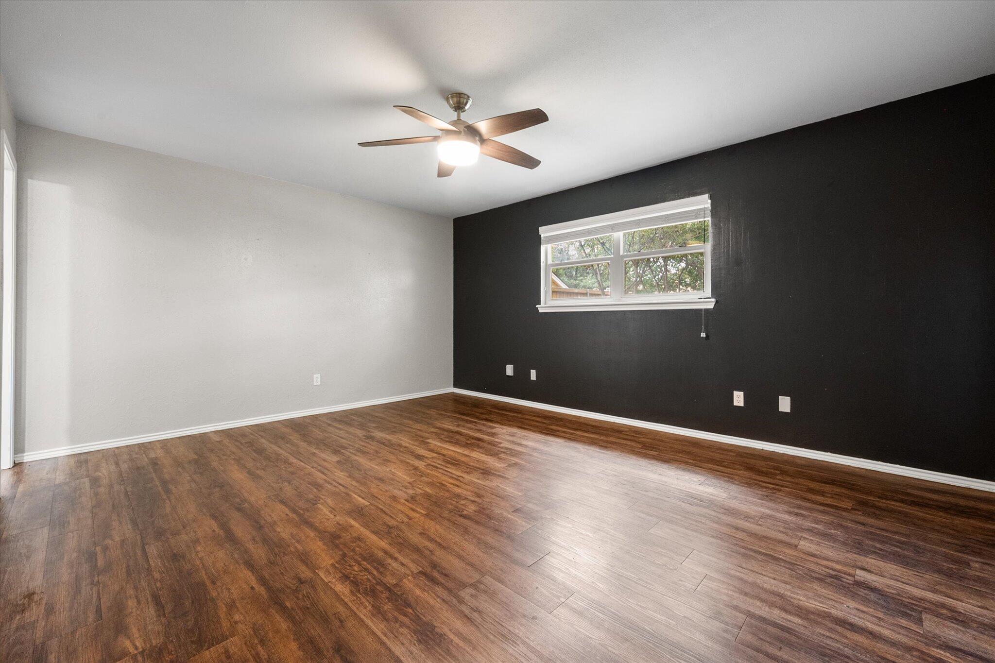 5309 77th Street Lubbock, TX 79424 - Photo 25 of 37 an empty room with wooden floor and windows