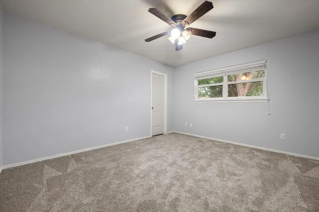 an empty room with chandelier fan