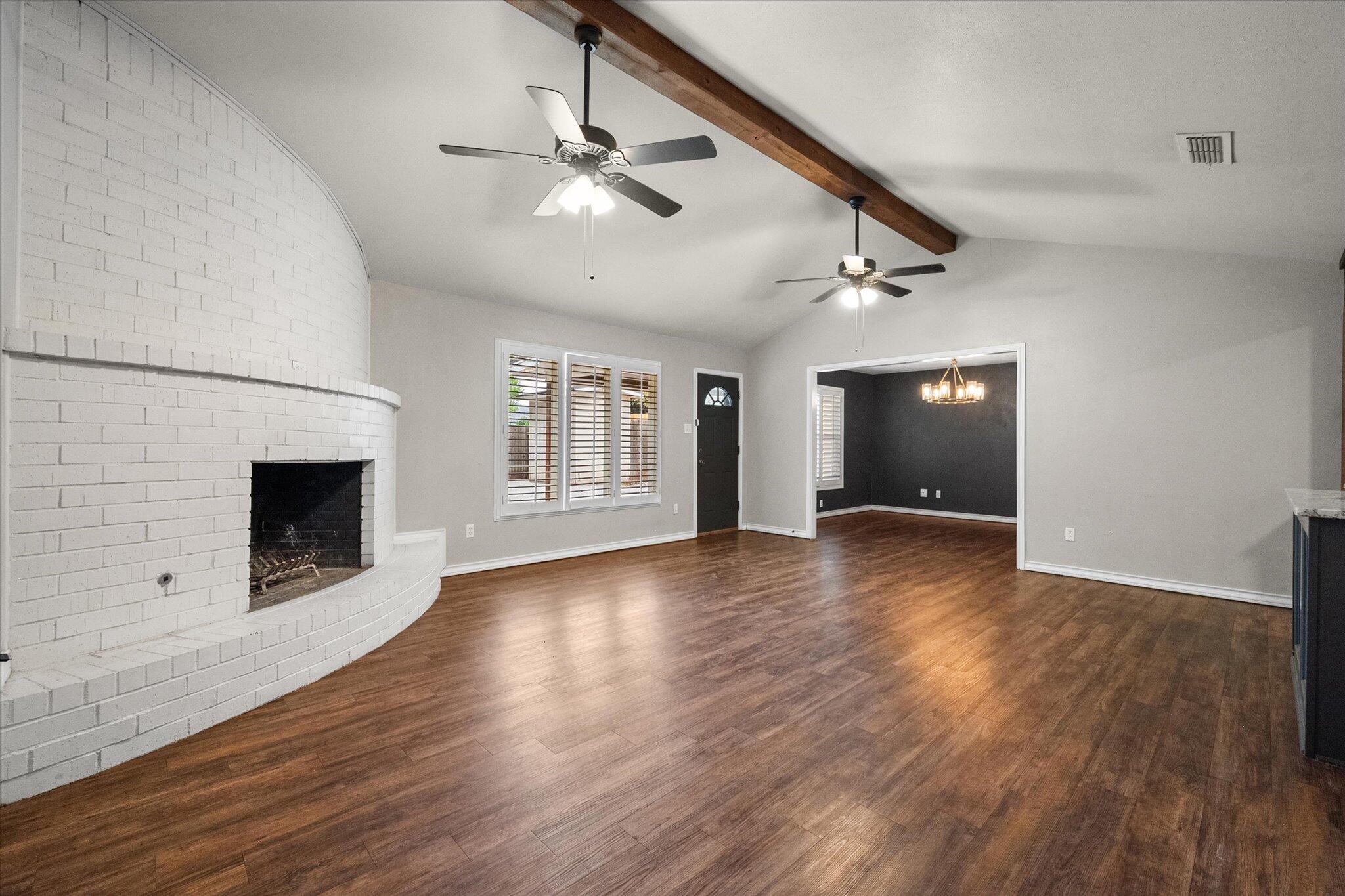 5309 77th Street Lubbock, TX 79424 - Photo 9 of 37 a view of an empty room with wooden floor fireplace and a window