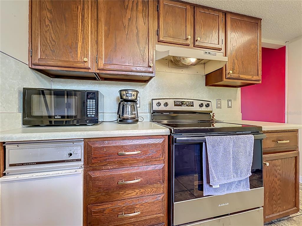 500 Newell Hill Road, Unit 108A Leesburg, FL 34748 - Photo 11 of 26 a kitchen with stainless steel appliances granite countertop a stove and a microwave