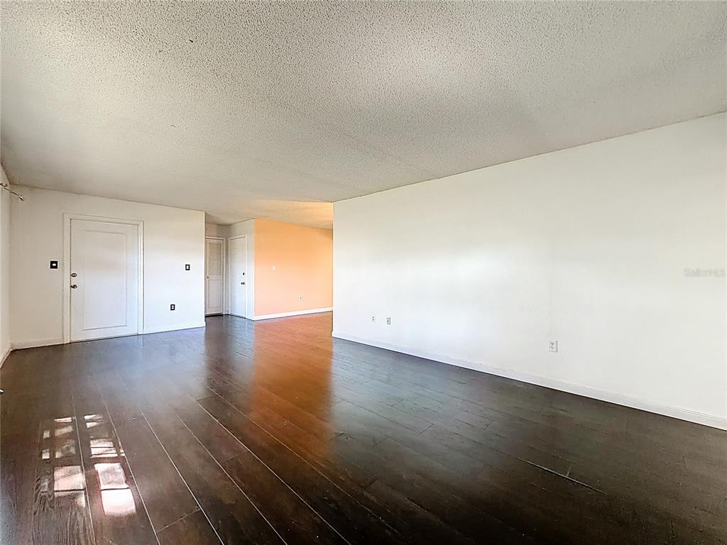 500 Newell Hill Road, Unit 108A Leesburg, FL 34748 - Photo 11 of 44 an empty room with wooden floor and windows