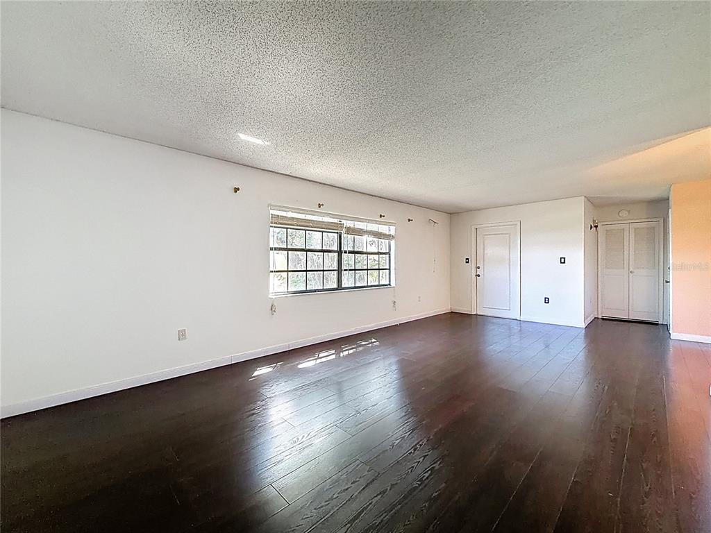 500 Newell Hill Road, Unit 108A Leesburg, FL 34748 - Photo 12 of 44 an empty room with wooden floor and windows