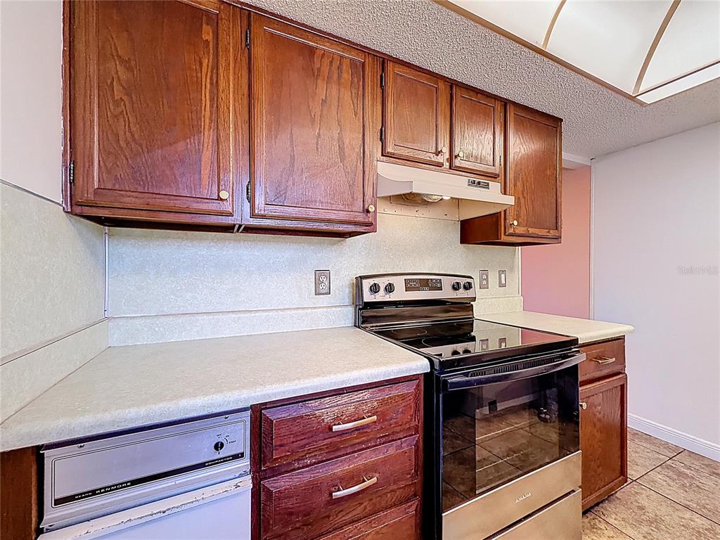 500 Newell Hill Road, Unit 108A Leesburg, FL 34748 - Photo 16 of 44 a kitchen with wooden cabinets and a stove top oven