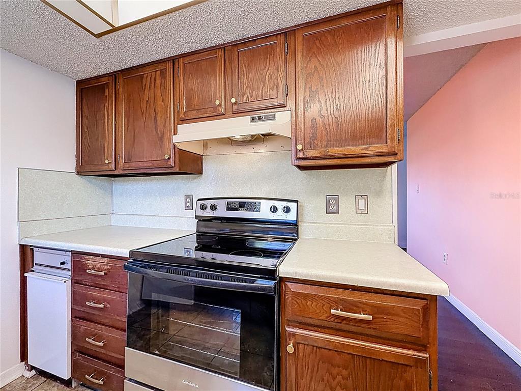 500 Newell Hill Road, Unit 108A Leesburg, FL 34748 - Photo 17 of 44 a kitchen with wooden cabinets and a stove top oven