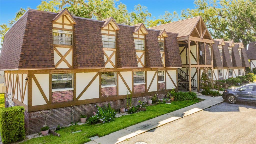500 Newell Hill Road, Unit 108A Leesburg, FL 34748 - Photo 2 of 44 a view of a brick house with large windows and a yard