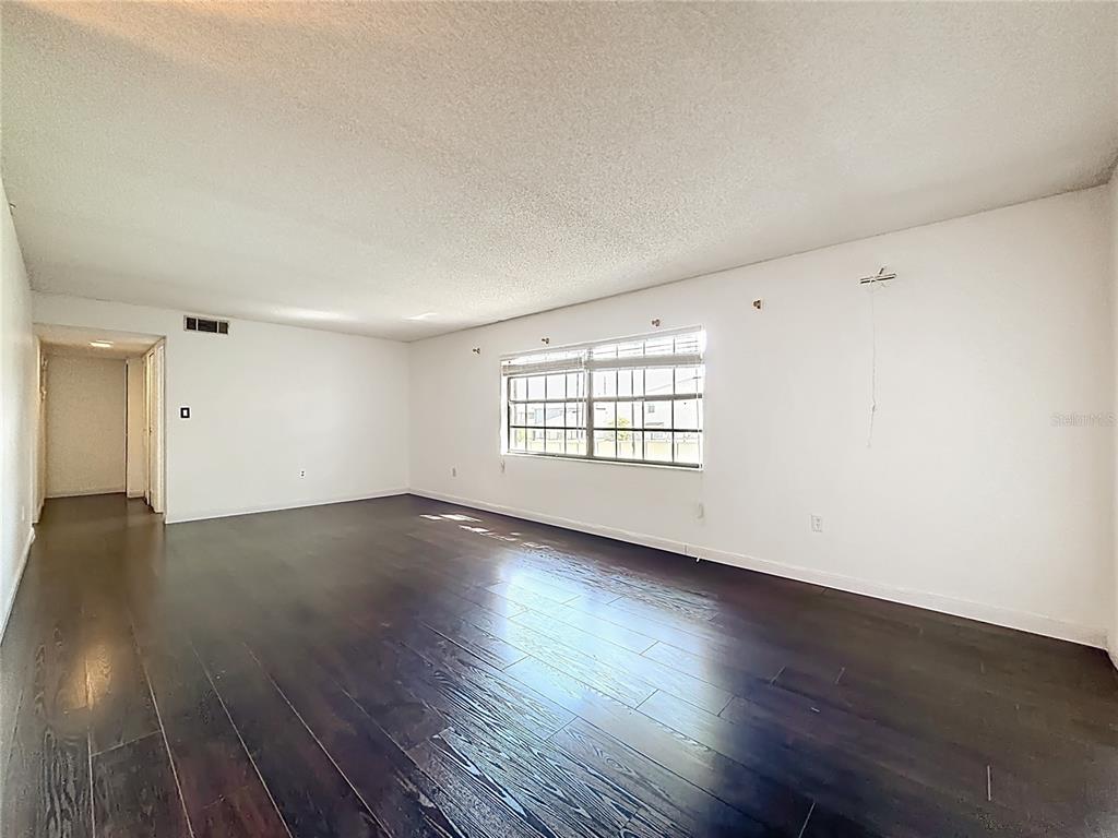 500 Newell Hill Road, Unit 108A Leesburg, FL 34748 - Photo 8 of 44 an empty room with wooden floor and windows