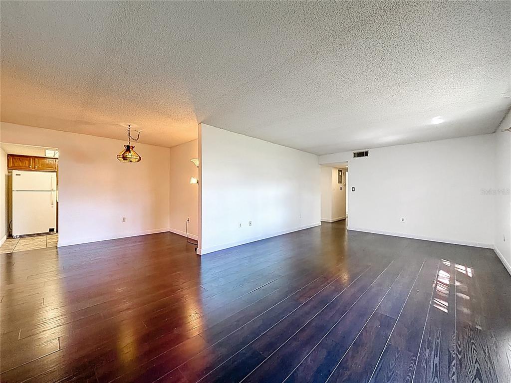 500 Newell Hill Road, Unit 108A Leesburg, FL 34748 - Photo 9 of 44 an empty room with wooden floor and windows