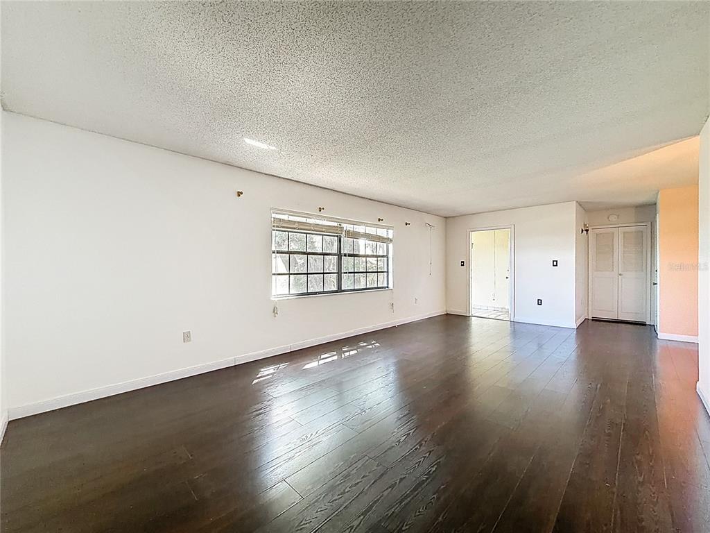 500 Newell Hill Road, Unit 108A Leesburg, FL 34748 - Photo 10 of 44 an empty room with wooden floor and windows