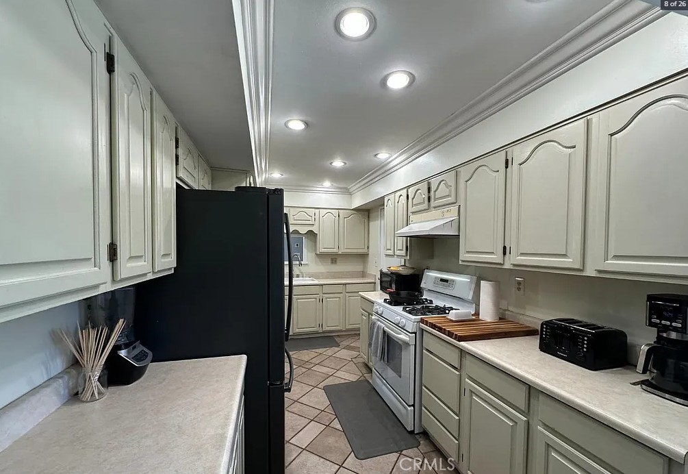 12745 Keith Place Tustin, CA 92780 - Photo 6 of 14 a kitchen with a sink a refrigerator and cabinets