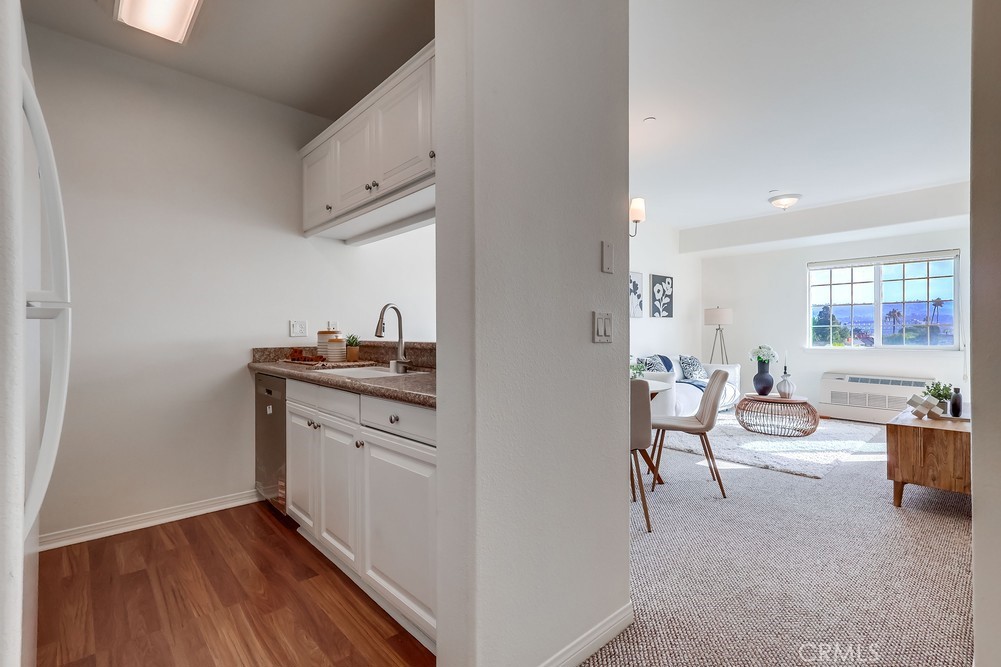 3120 Sepulveda Boulevard, Unit 412 Torrance, CA 90505 - Photo 11 of 40 a hallway with white cabinets and wooden floor