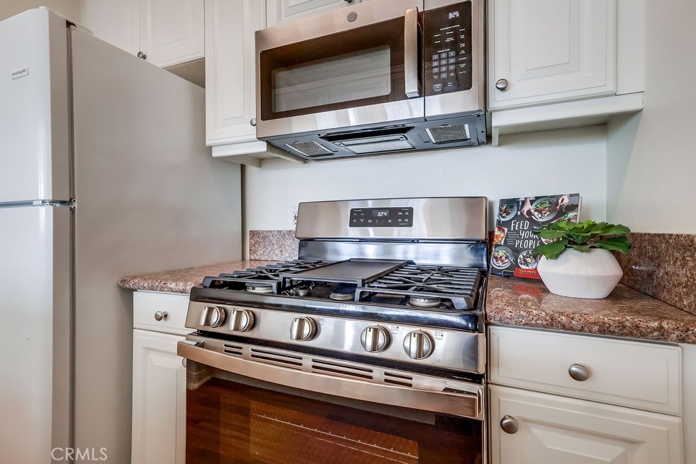 3120 Sepulveda Boulevard, Unit 412 Torrance, CA 90505 - Photo 14 of 40 a kitchen with stainless steel appliances granite countertop a stove and a microwave