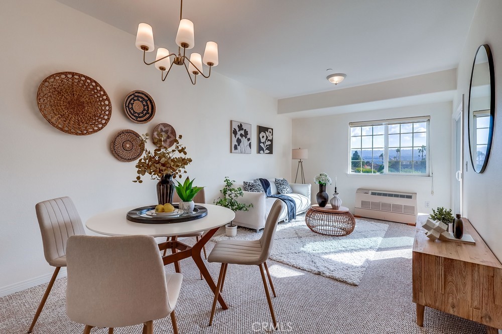 3120 Sepulveda Boulevard, Unit 412 Torrance, CA 90505 - Photo 16 of 40 a dining room with furniture a chandelier and wooden floor
