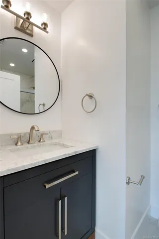 a bathroom with a granite countertop sink a mirror and vanity