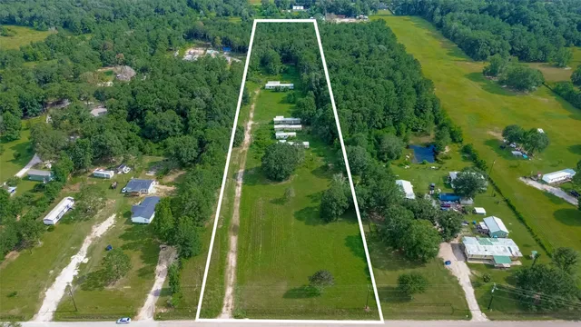 a aerial view of residential houses with outdoor space and trees