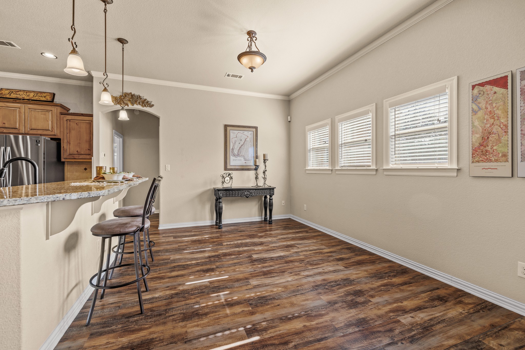 204 Skyline Road Georgetown, TX 78628 - Photo 18 of 40 Kitchen with a kitchen bar, freestanding refrigerator, arched walkways, wood finish cabinets, and light stone countertops