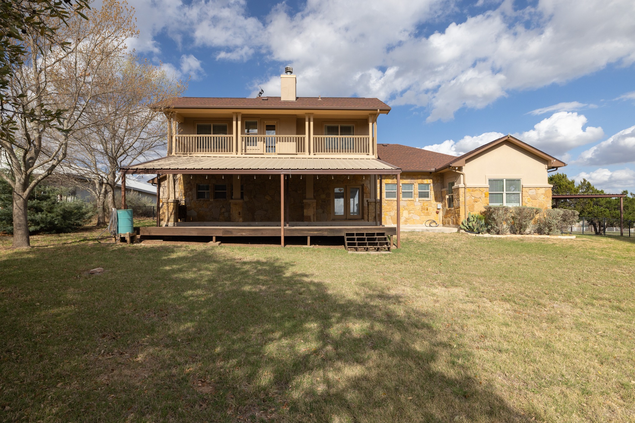 204 Skyline Road Georgetown, TX 78628 - Photo 35 of 40 Rear view of house with stone siding, a lawn, and a chimney