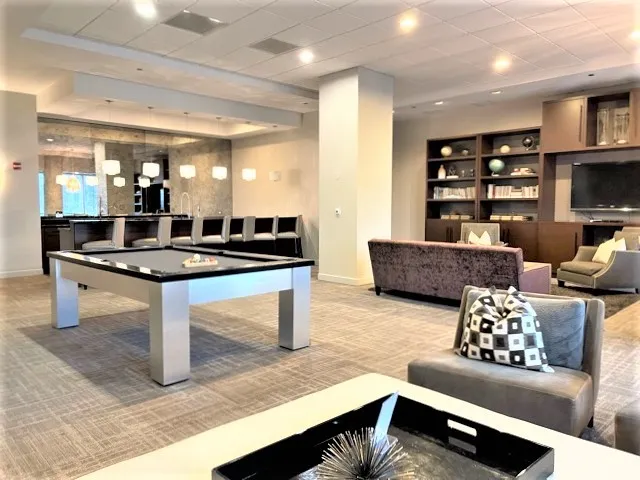 a living room with furniture a large window and gym equipment