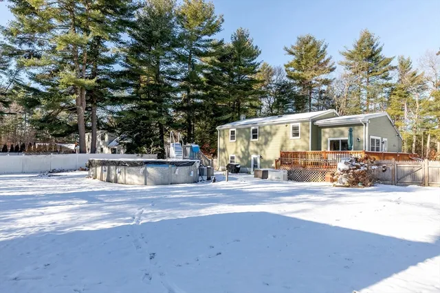a view of a house with large tree and wooden fence