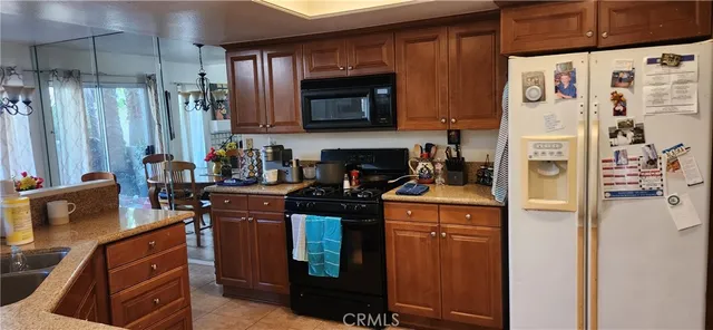 a kitchen with stainless steel appliances granite countertop a refrigerator and a stove top oven